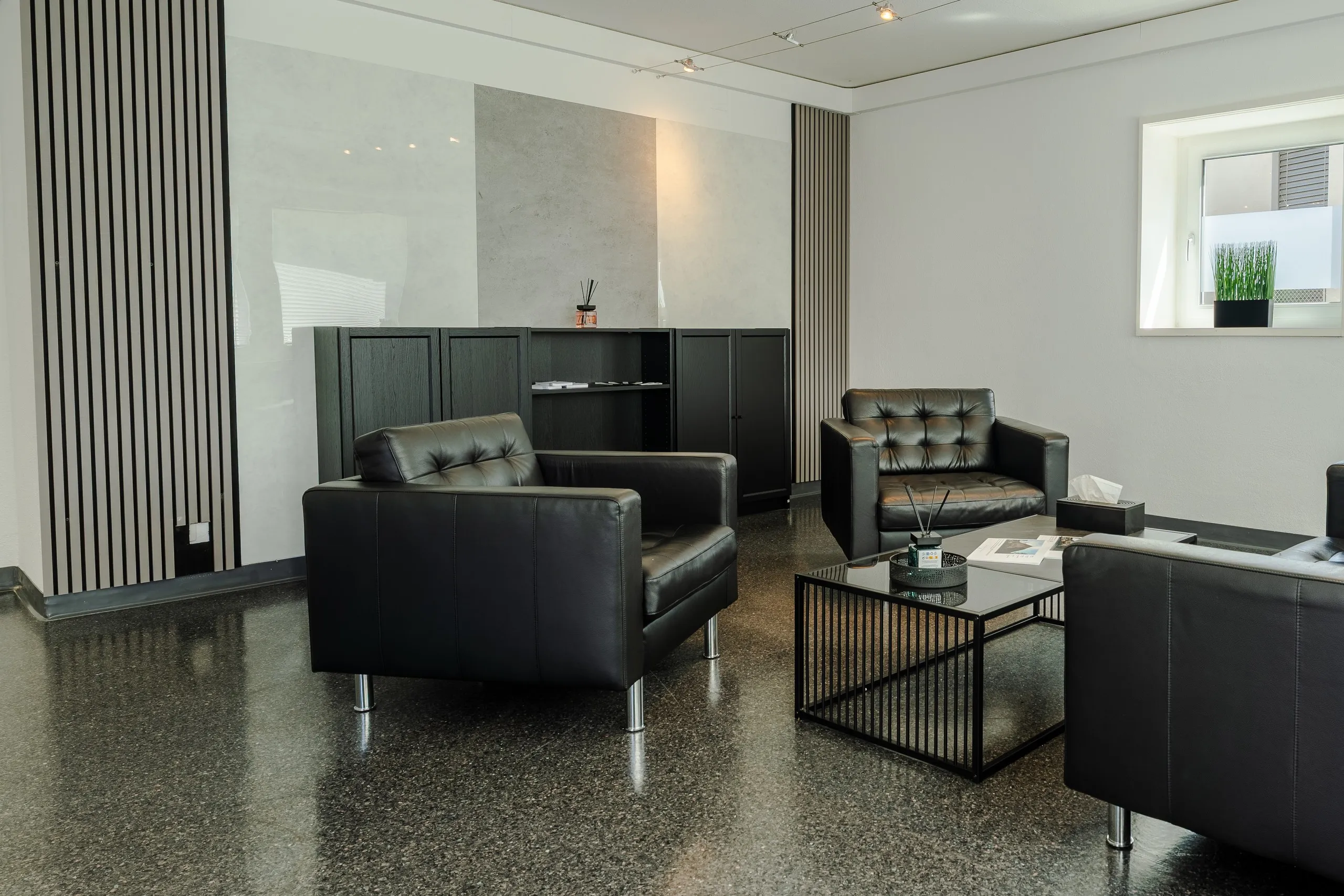 Büro und Empfang mit schwarzen Sesseln und Lounge
