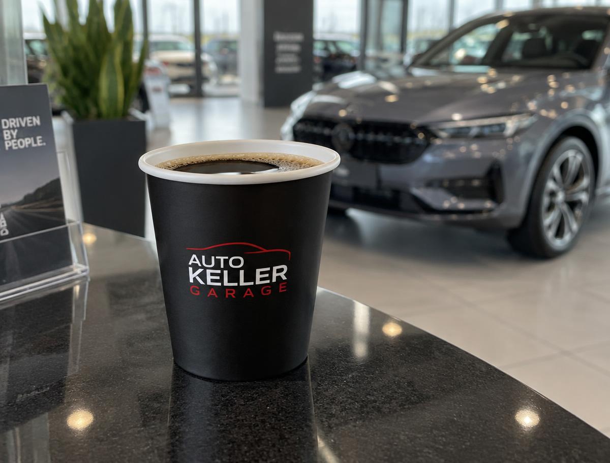 Offener schwarzer Coffee-to-go-Becher ohne Deckel mit Garagenlogo in einem Autohaus